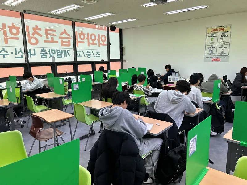 고등 영수학원 책상에서 교재를 살펴보는 학습 공간